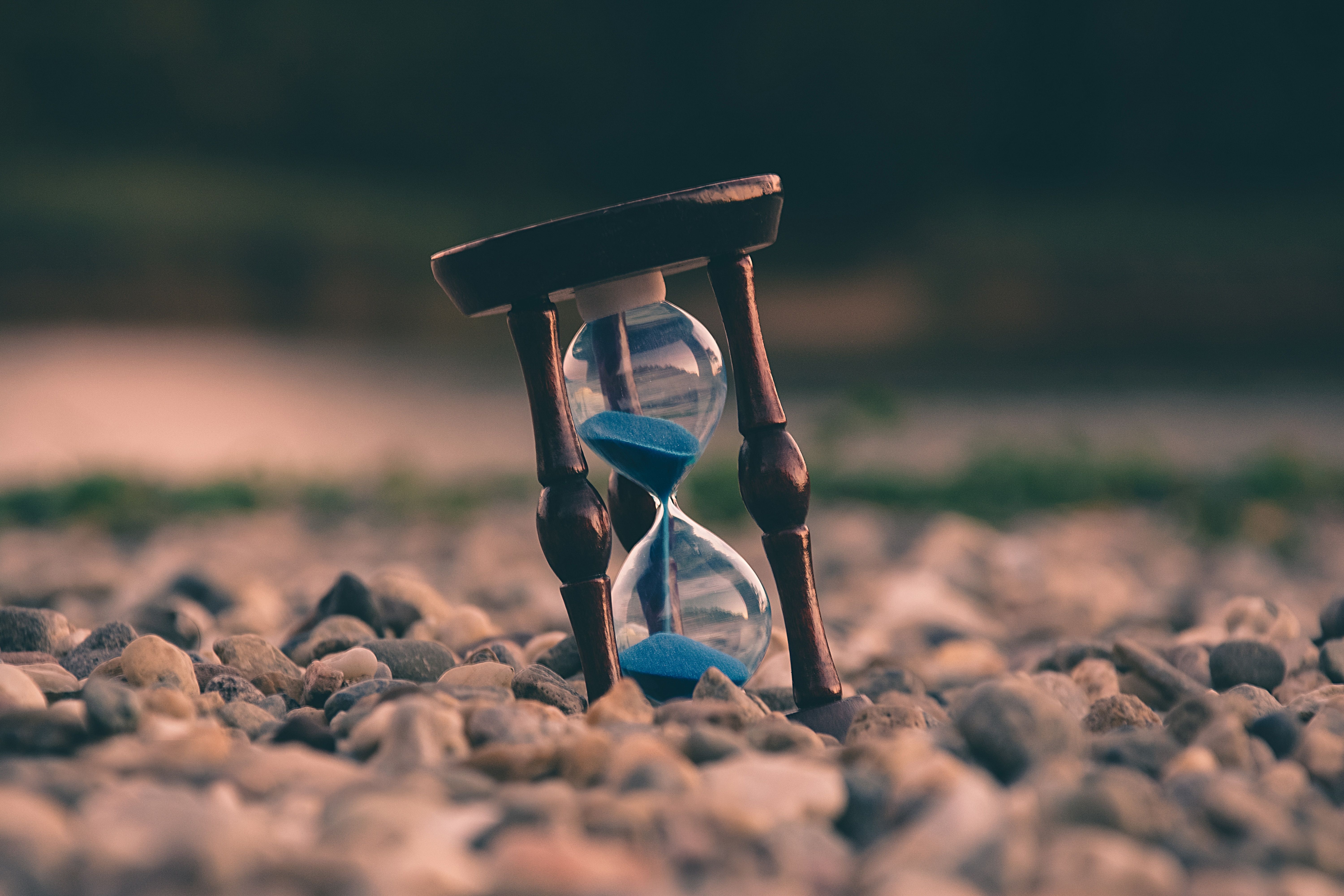 a sand timer at an angle, on some pebbles